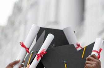 close up hands holding diplomas and caps 23 2148950575