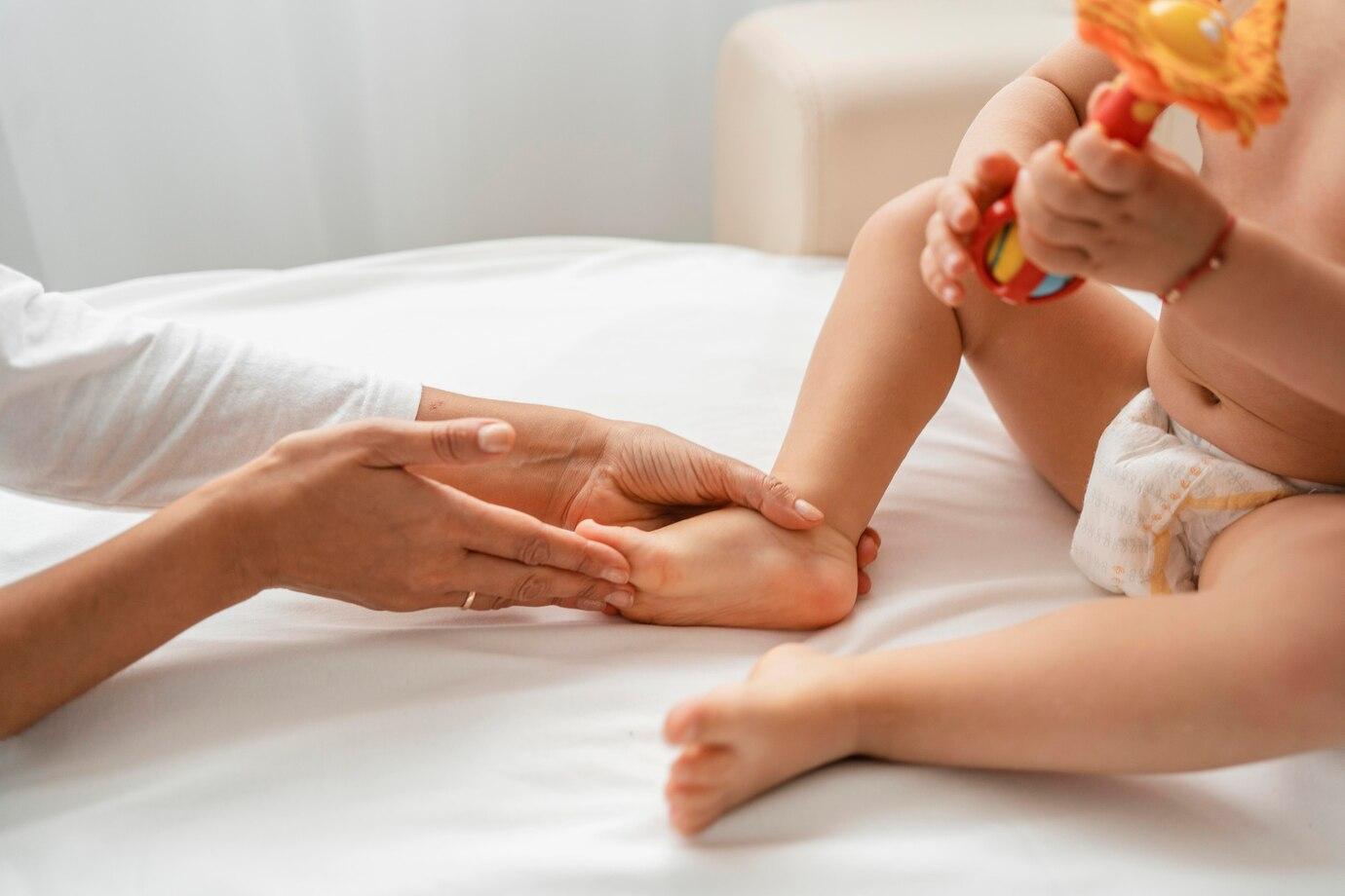 osteopathist treating a baby girl s feet 23 2148776199